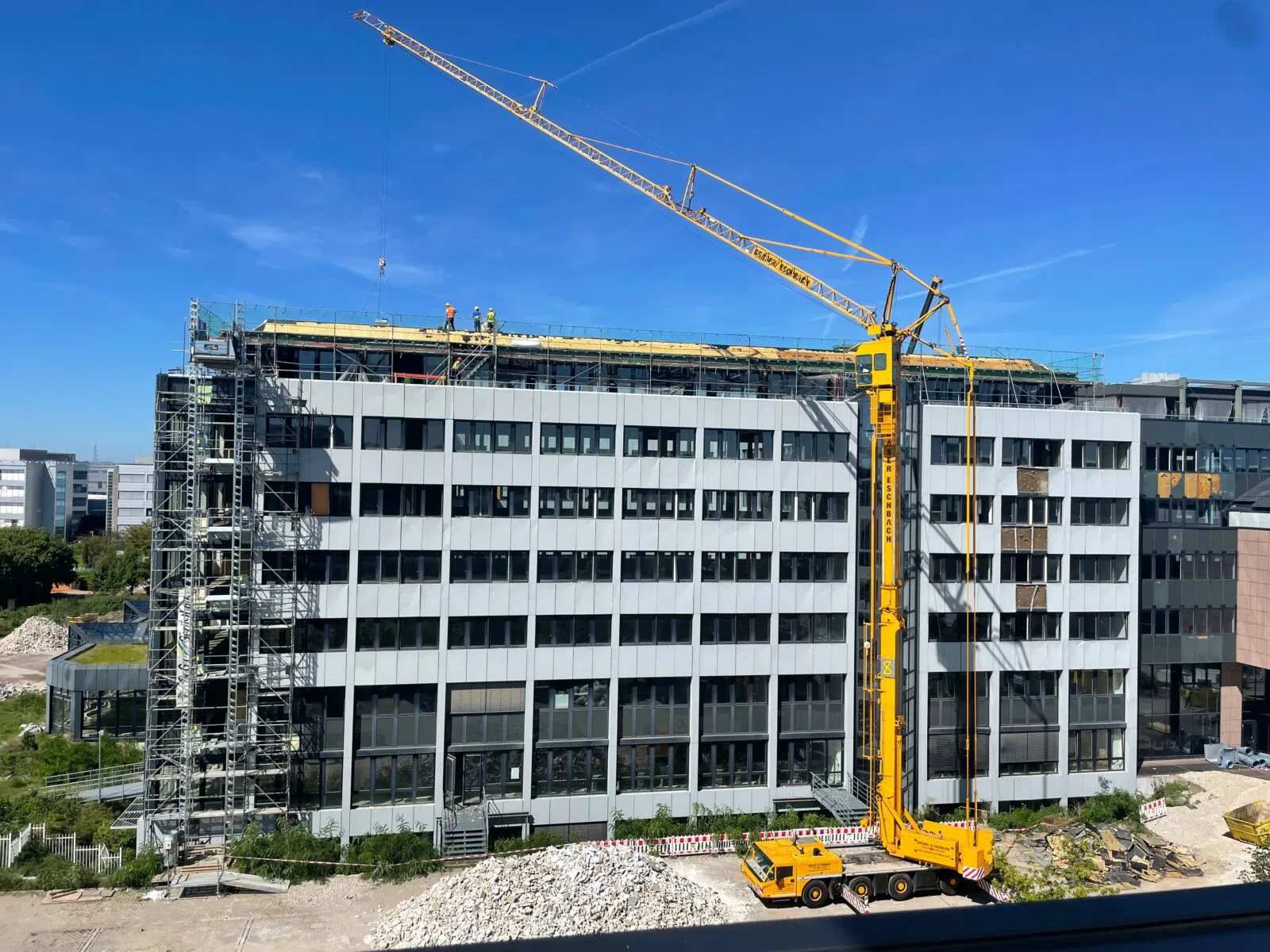 a crane is standing in front of a building under construction